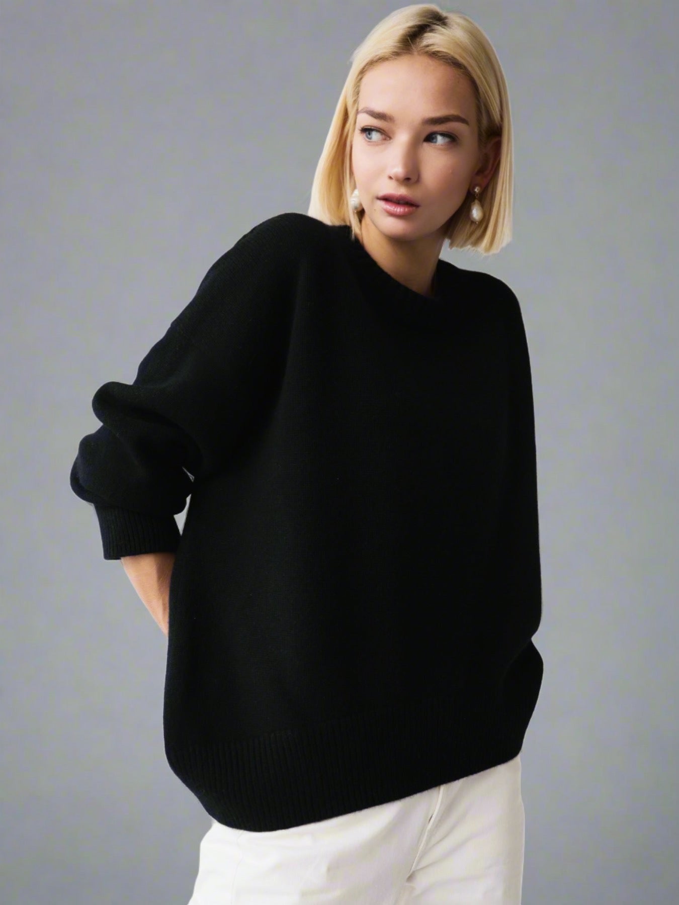 Woman wearing a black oversized cashmere sweater.