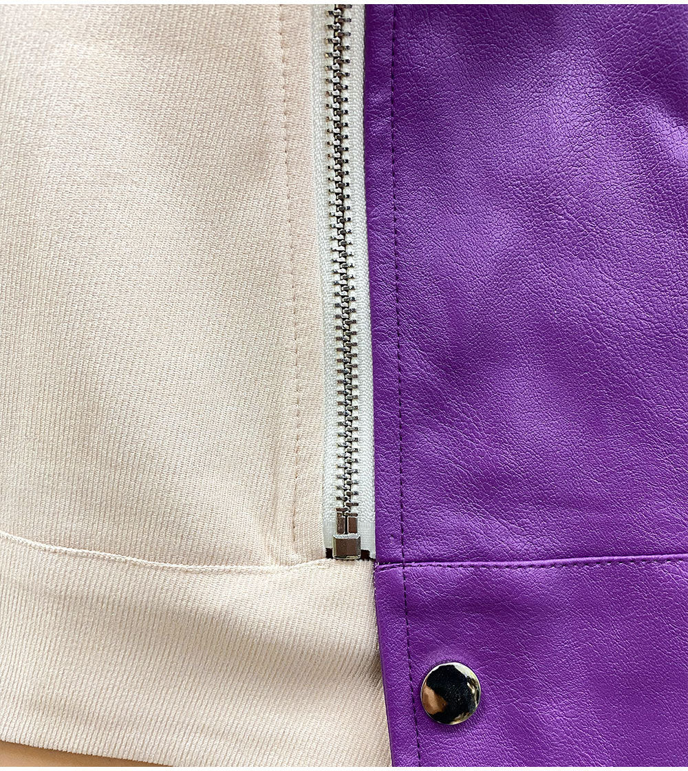 Woman wearing a Color-Block Leather and Fabric Jacket with a purple leather front and beige fabric sleeves and back, featuring a zip-up front and snap-button details.