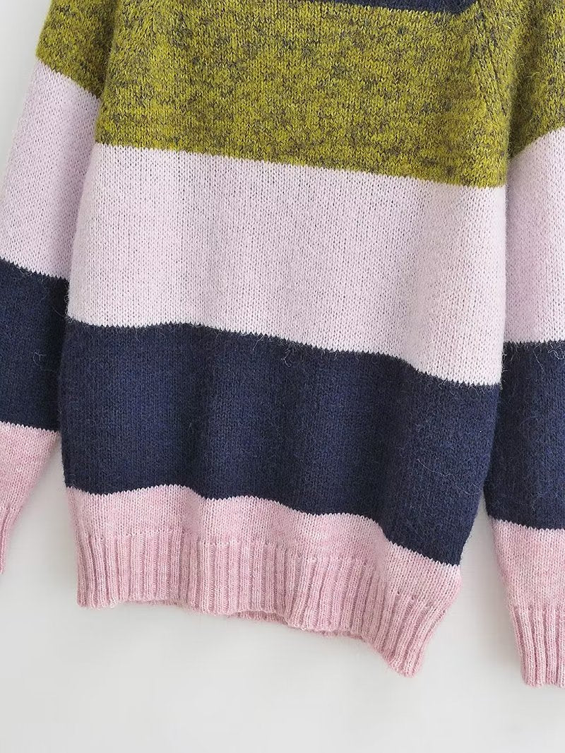 Woman wearing a colorblock knit sweater with navy, olive green, and soft pink stripes.