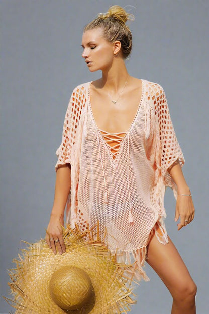 Woman wearing a pink fringe beach cover-up.