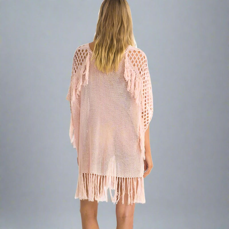 Woman wearing a pink fringe beach cover-up.