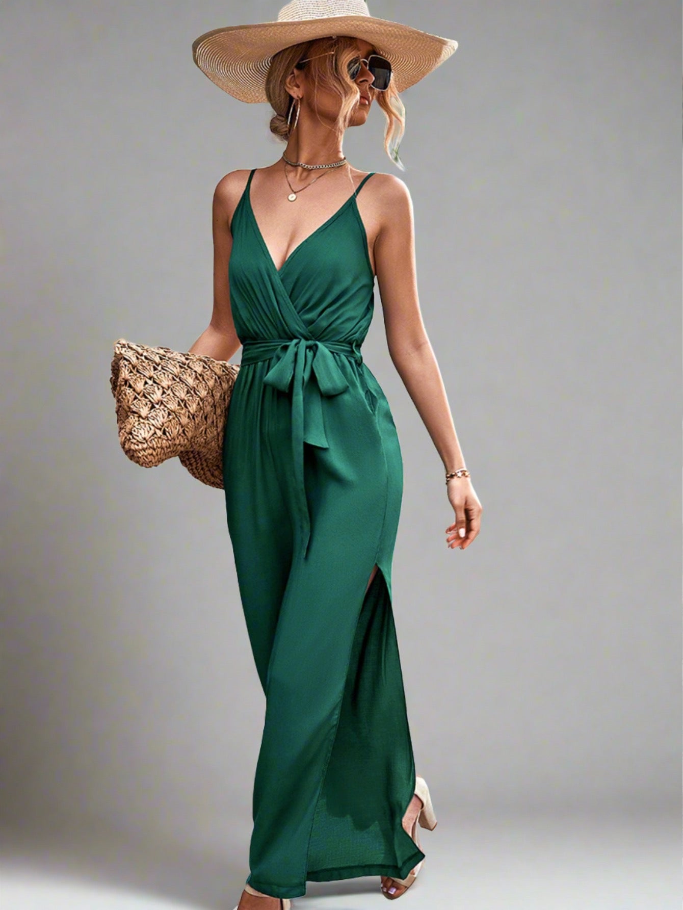 Woman wearing the Oasis Wide-Leg Jumpsuit in green, perfect for vacation.