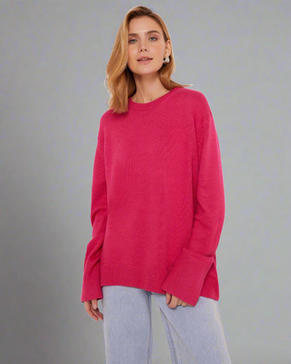 Woman wearing a coral red oversized cashmere sweater.