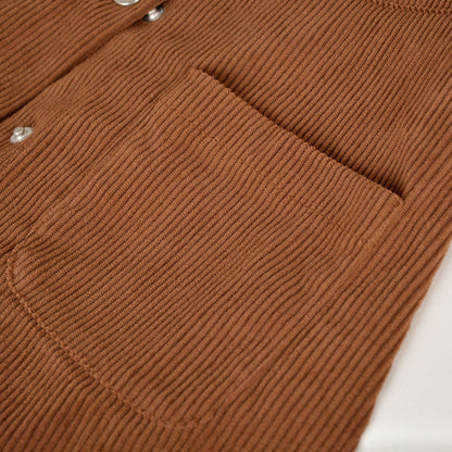 Woman wearing a High-Waist Corduroy Button-Up Skirt in a warm, earthy tone, featuring a front button-up closure and two front pockets.