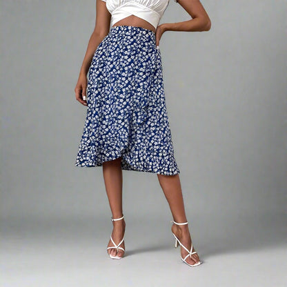 Woman wearing a blue midi skirt with a white floral print, paired with a white crop top and white strappy heels