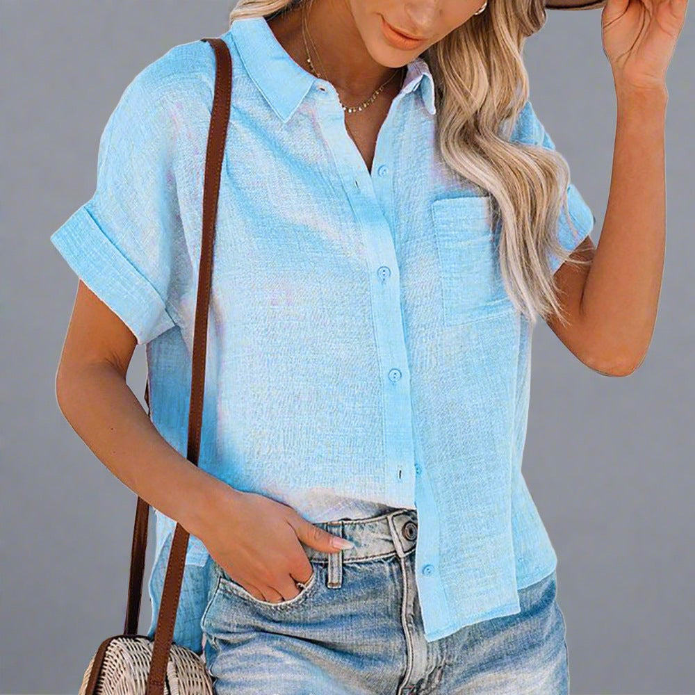 Woman wearing a Lightweight Linen Button-Up Shirt in white, featuring a relaxed fit, short sleeves, and a front pocket, paired with jeans.