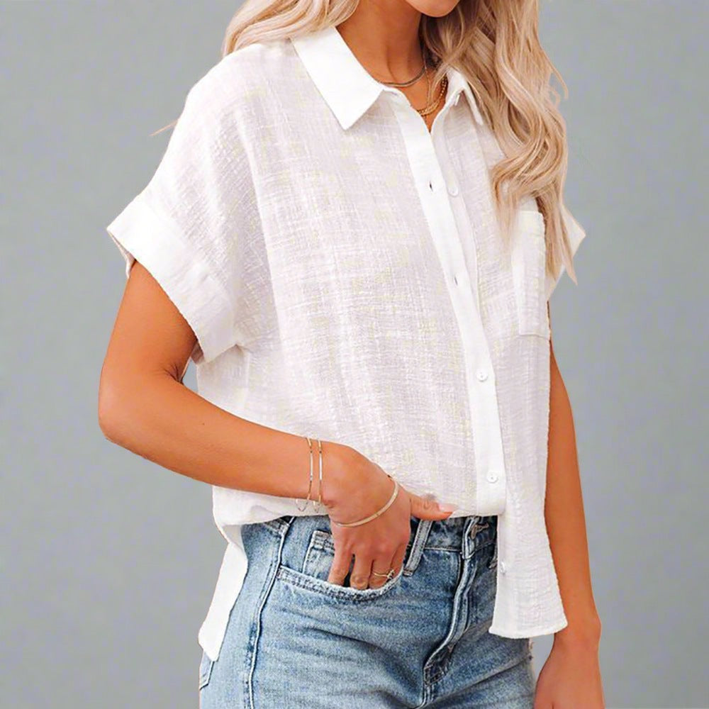 Woman wearing a Lightweight Linen Button-Up Shirt in white, featuring a relaxed fit, short sleeves, and a front pocket, paired with jeans.