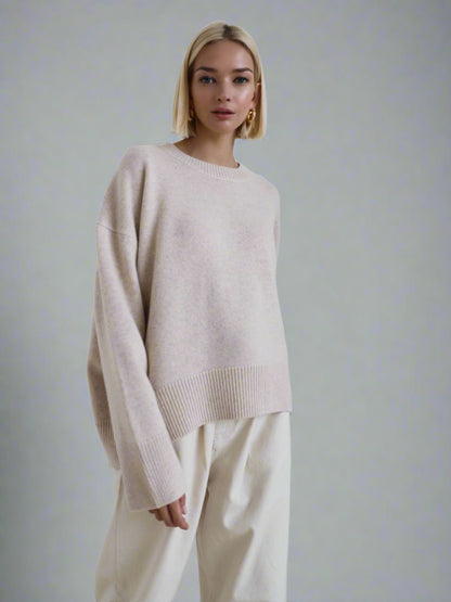 Woman wearing a beige oversized cashmere sweater.