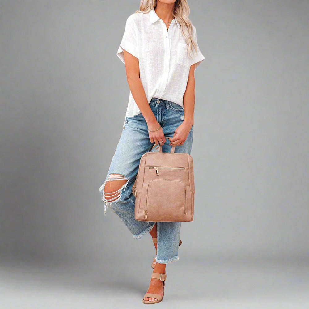 Woman wearing a Lightweight Linen Button-Up Shirt in white, featuring a relaxed fit, short sleeves, and a front pocket, paired with jeans.