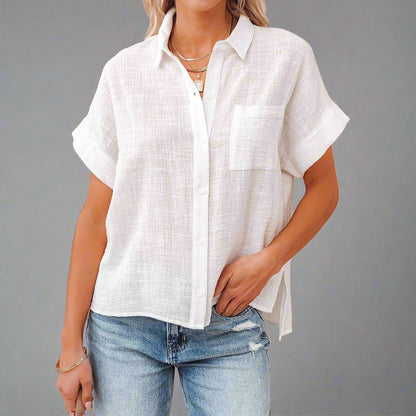 Woman wearing a Lightweight Linen Button-Up Shirt in white, featuring a relaxed fit, short sleeves, and a front pocket, paired with jeans.