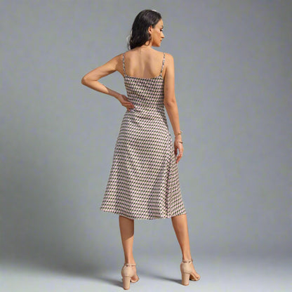 Woman wearing a Geometric Pattern Midi Dress with adjustable spaghetti straps.