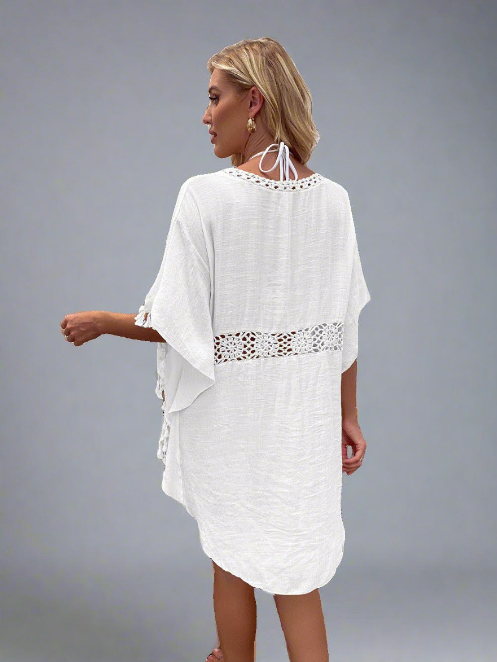 Woman wearing a boho crochet tassel cover-up in white