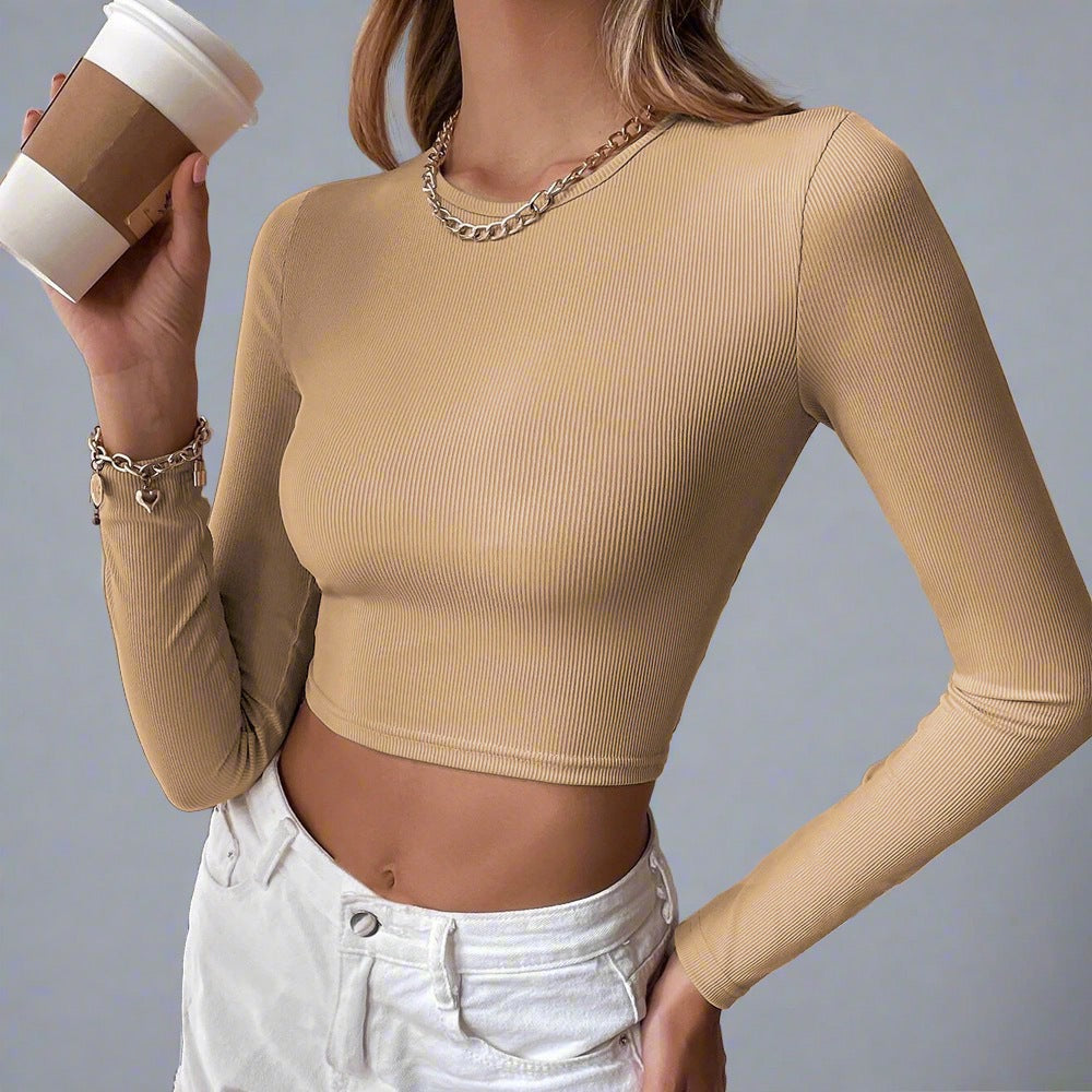 Model wearing the Voyager Elegance Open-Back Long Sleeve Crop Top in khaki, ideal for stylish travel outfits