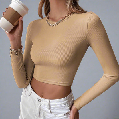 Model wearing the Voyager Elegance Open-Back Long Sleeve Crop Top in khaki, ideal for stylish travel outfits