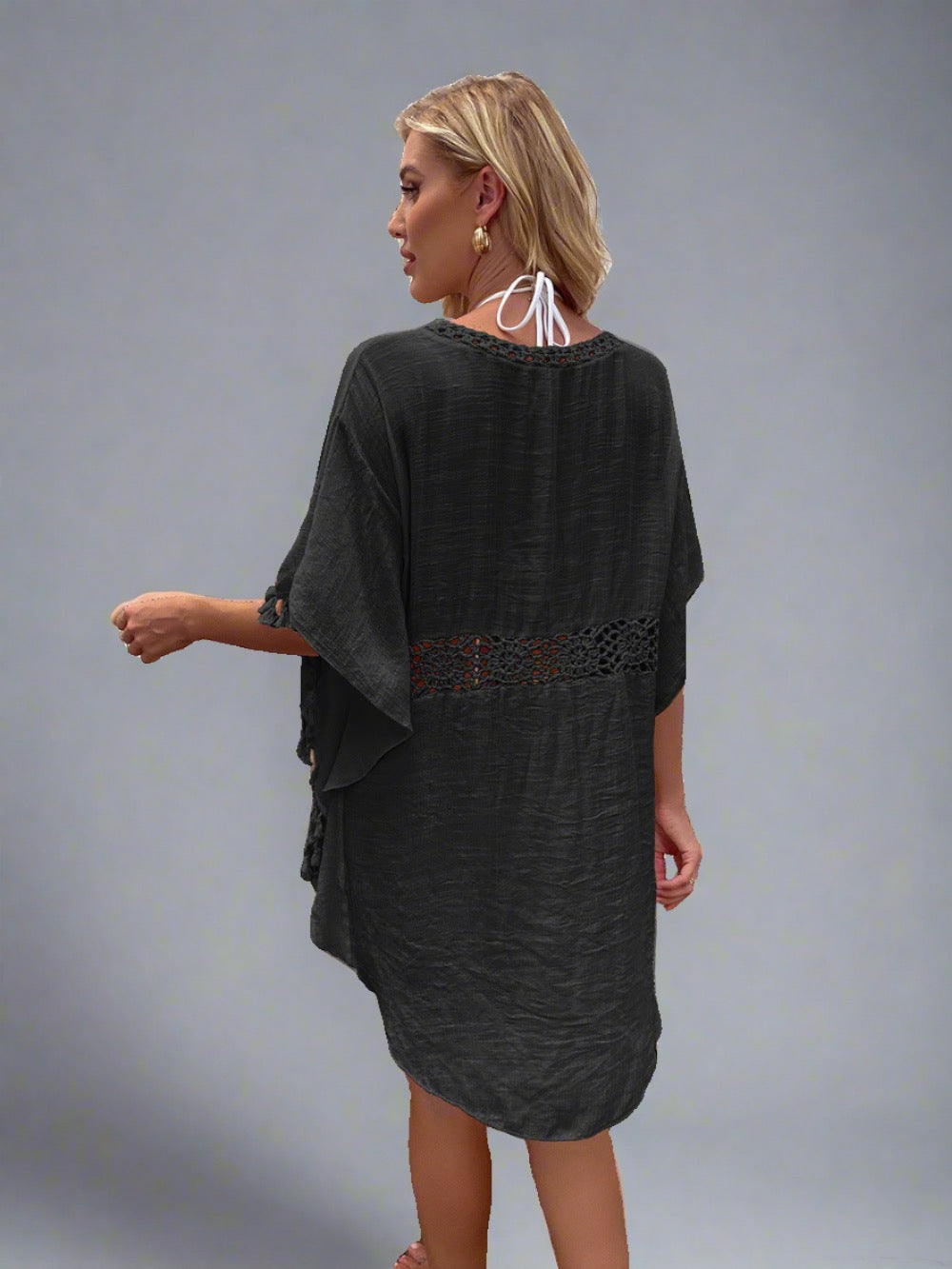 Woman wearing a boho crochet tassel cover-up in black