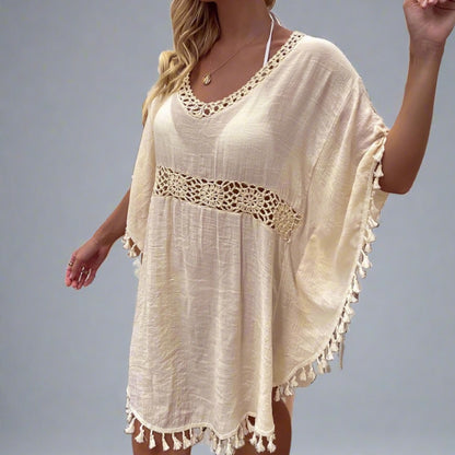 Woman wearing a boho crochet tassel cover-up in apricot.