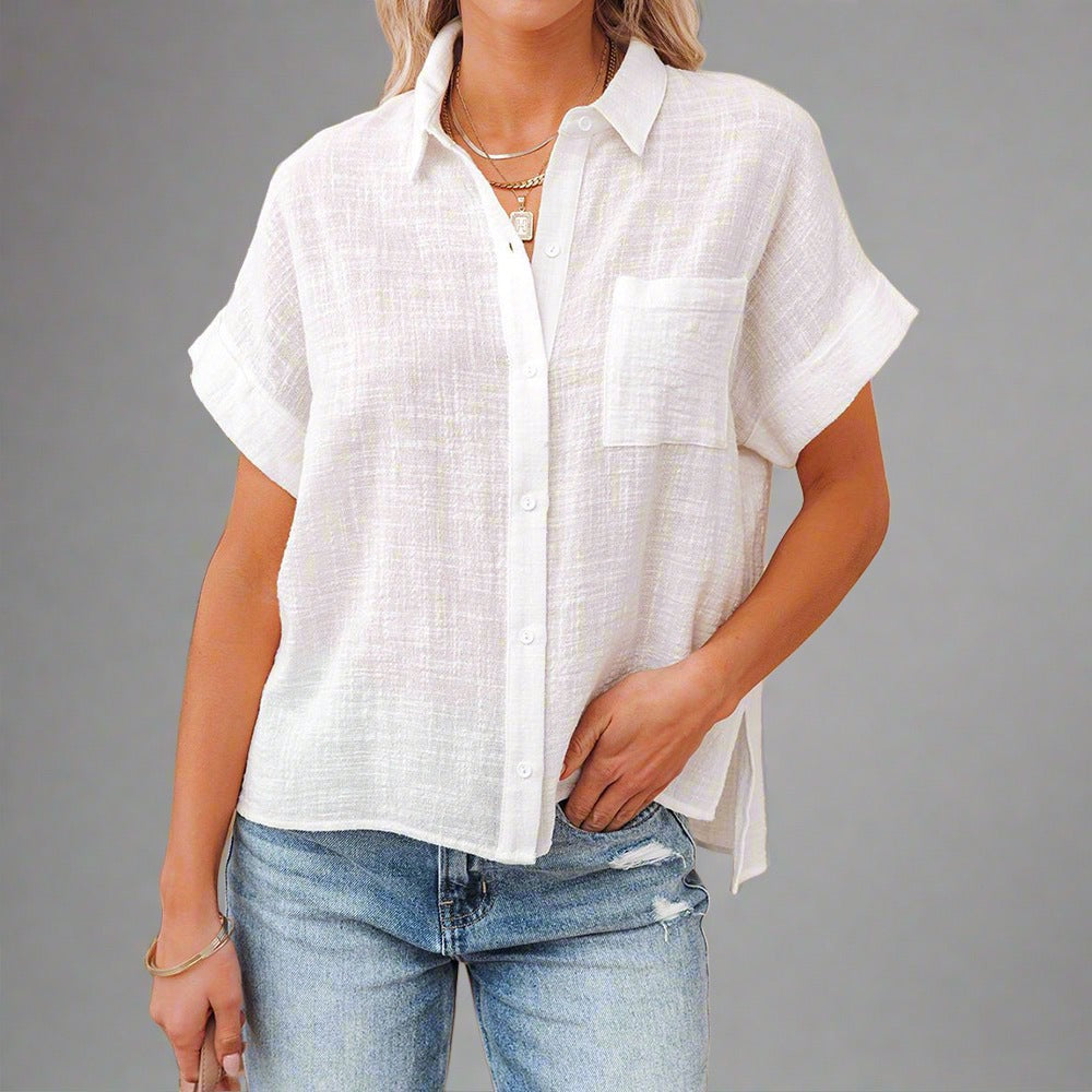 Woman wearing a Lightweight Linen Button-Up Shirt in white, featuring a relaxed fit, short sleeves, and a front pocket, paired with jeans.