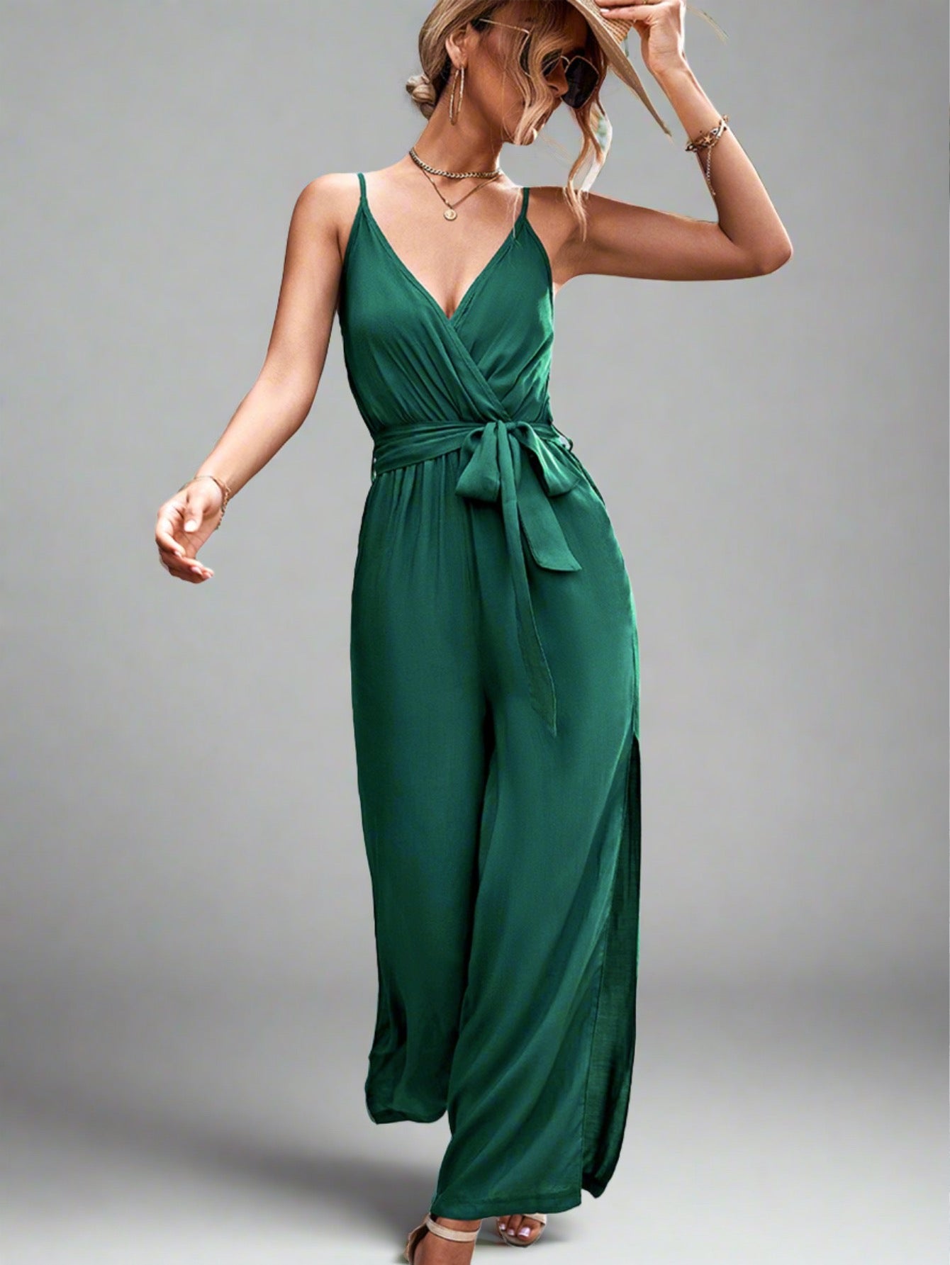 Woman wearing the Oasis Wide-Leg Jumpsuit in green, perfect for vacation.