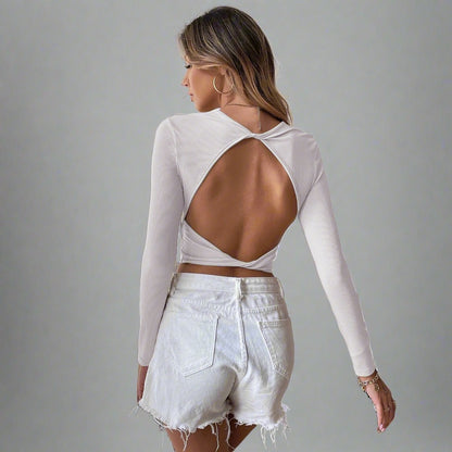 Model wearing the Voyager Elegance Open-Back Long Sleeve Crop Top in white ideal for stylish travel outfits