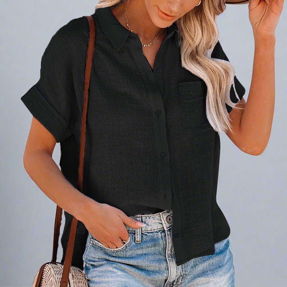 Woman wearing a Lightweight Linen Button-Up Shirt in white, featuring a relaxed fit, short sleeves, and a front pocket, paired with jeans.