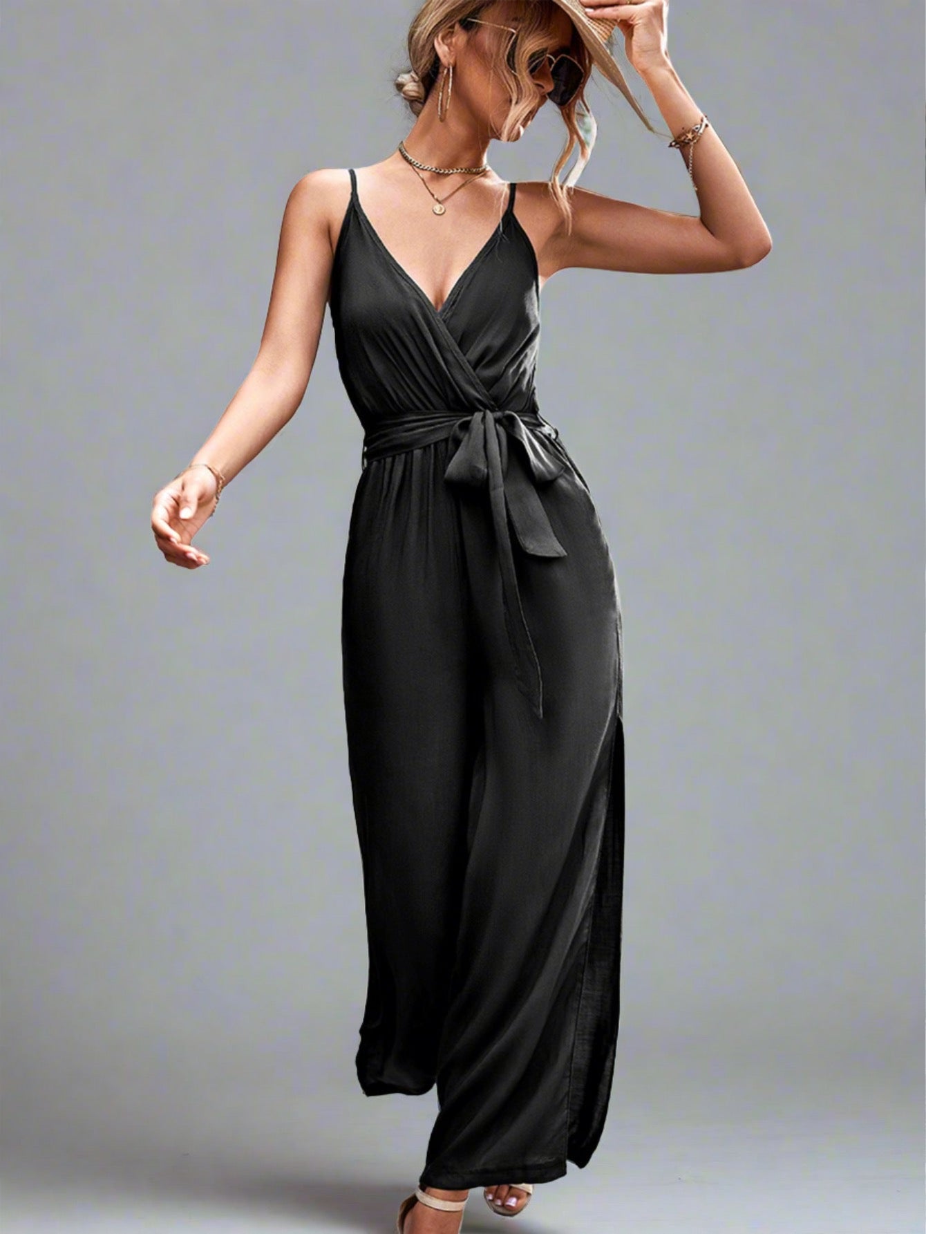 Woman wearing the Oasis Wide-Leg Jumpsuit in black, perfect for vacation.