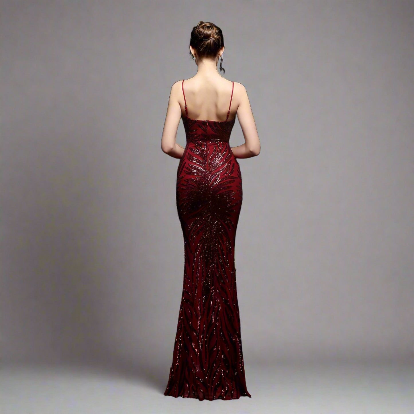 Model wearing Luxury Traveler's Sequin Gala Gown in maroon, featuring a body-hugging silhouette with intricate sequin details and spaghetti straps