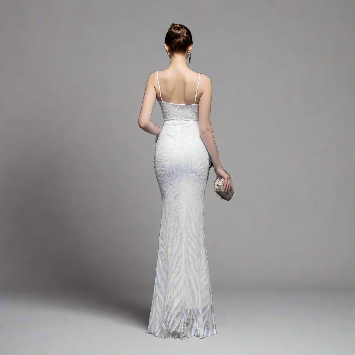 Model wearing Luxury Traveler's Sequin Gala Gown in white, featuring a body-hugging silhouette with intricate sequin details and spaghetti straps